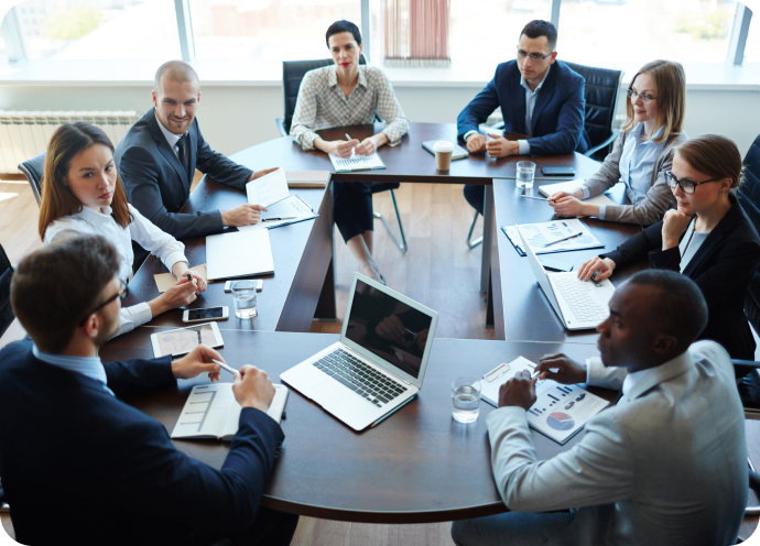 GettyImages-603992138 1 A group of people sitting around a table.
